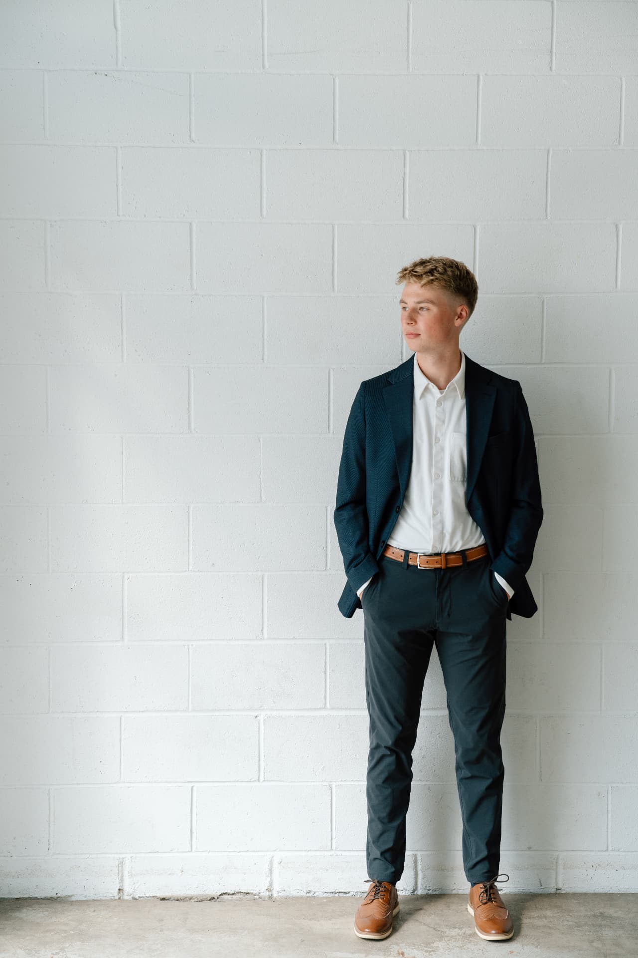 Matt Schertzer, licensed professional counselor, in a navy blazer against a white brick wall.